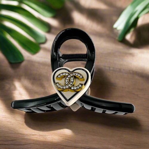 Hair Clip Black with a beige heart in the middle containing the Chanel symbol